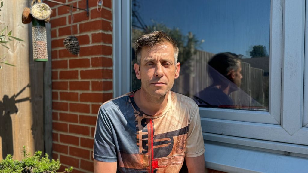 Gavin Porter in his garden next to a bird feeder