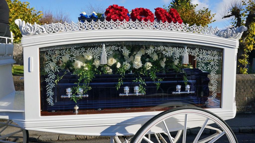 Payne's hearse, decorated with red and blue flowers bearing the words "son" and "daddy"