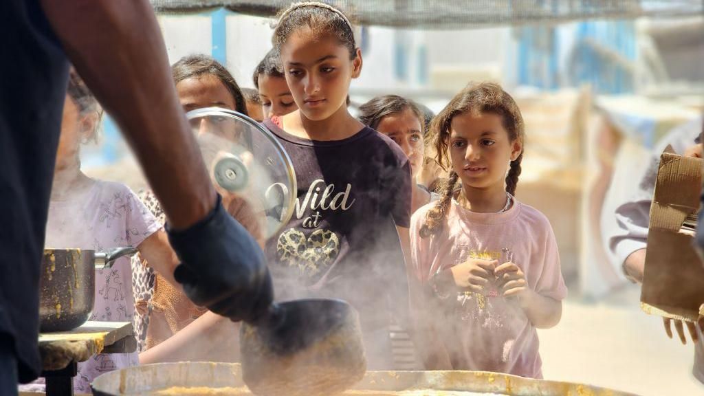 Displaced Palestinian children receiving food aid