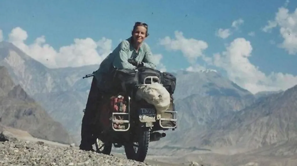 Jacqui Furneaux smiling leaning off the side of a motorbike