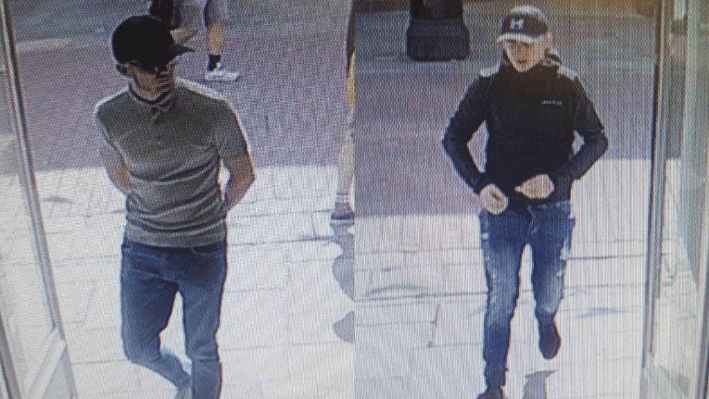 Side-by-side CCTV images of two men. One is wearing a dark hat, sunglasses, a grey polo shirt and blue jeans. The other is wearing a dark hat with the letter H on the front, a dark jacket, and blue jeans with tears in them