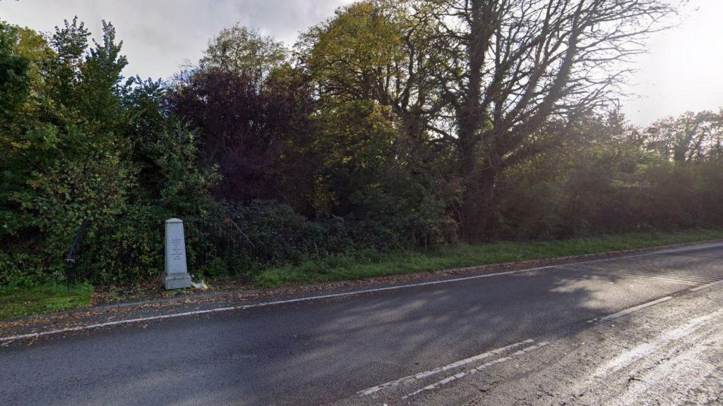 A memorial to the people buried at Horton Cemetery is a short grey stone monument at the site of the road