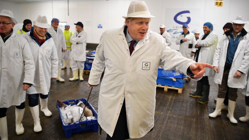 Boris Johnson drags a crate of fish