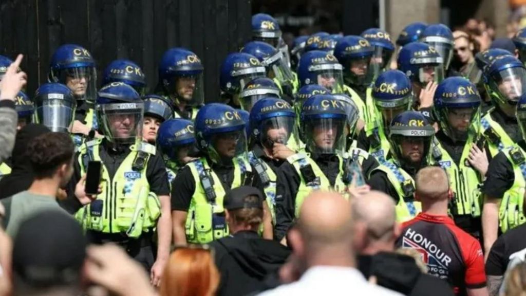 Police officers in riot gear during protests in Manchester