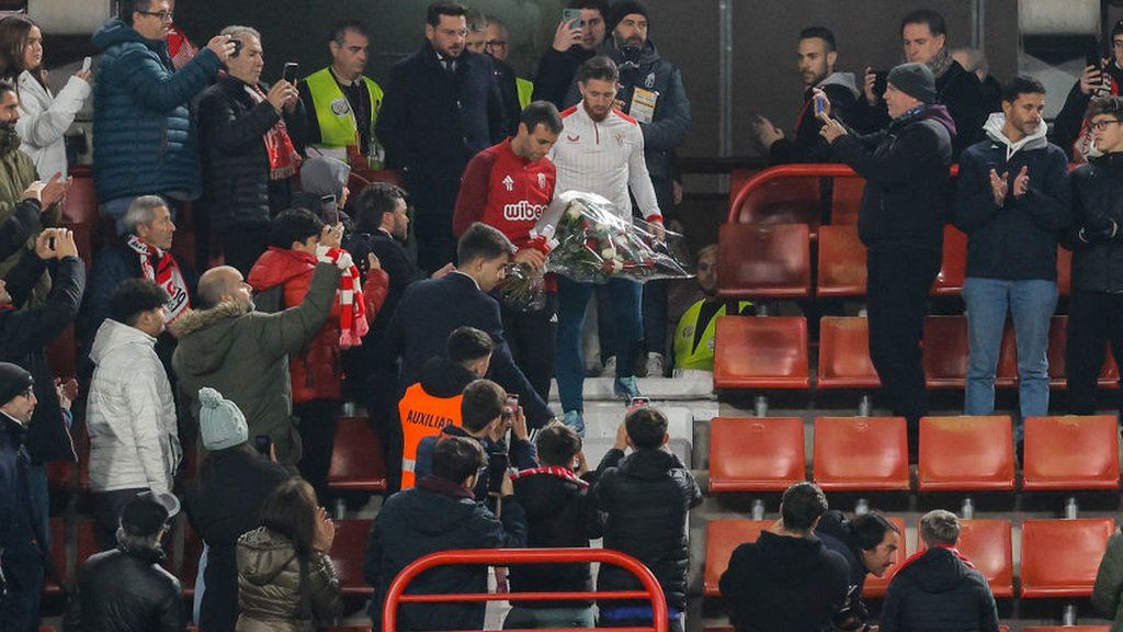 Victor Diaz of Granada and Iker Muniain of Athletic Bilbao lay flowers at the seat of a supporter who had died in the stands during the original fixture between the two sides