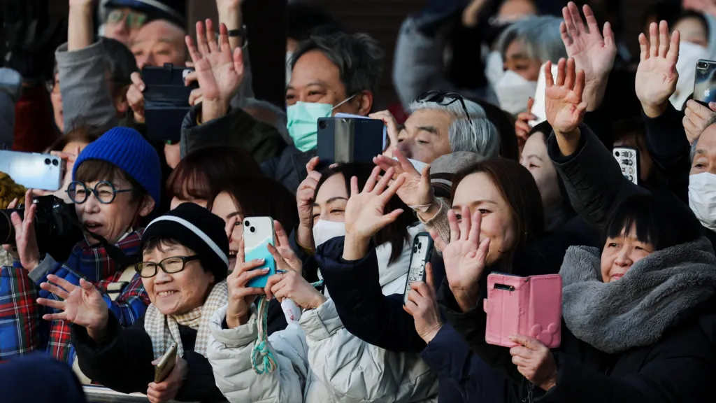 Voters hold up their phones and wave at a Sanae Takaichi campaign event in Japan