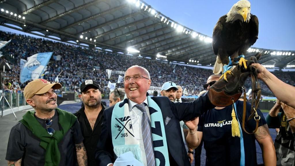 Sven Goran Eriksson holding an eagle in front of the fans at Lazio's Stadio Olimpico