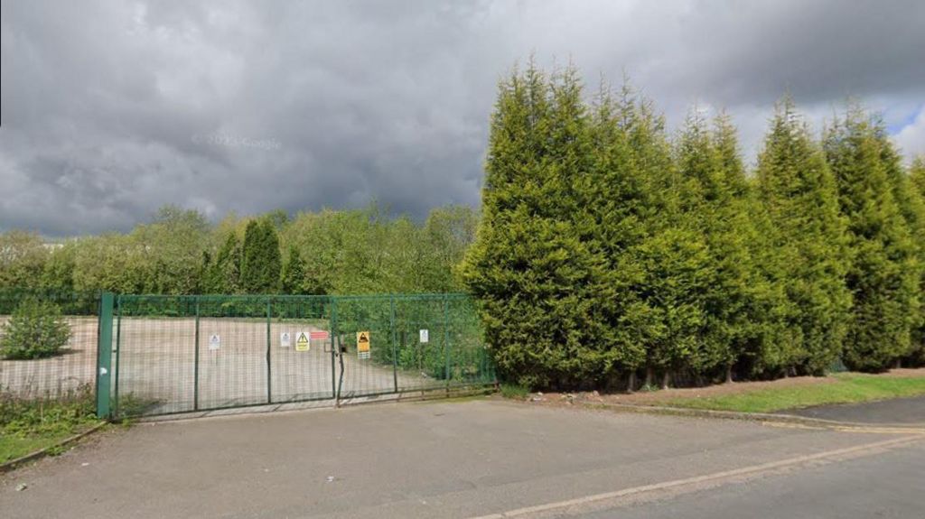 The closed gates of a former greenhouse 2000 site, they are green with signs attached to them