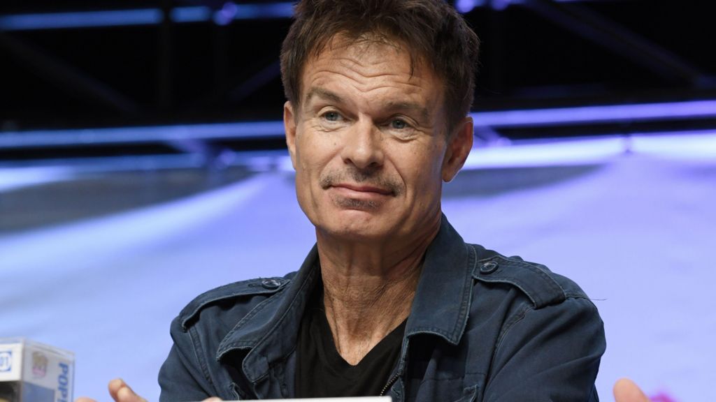 Patrick Muldoon at Comic Con last year, he is wearing a navy combat-style jacket and a black T-shirt