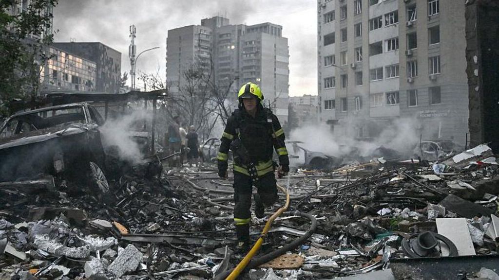 A rescuer walks through the wreckage of a building in Kyiv.