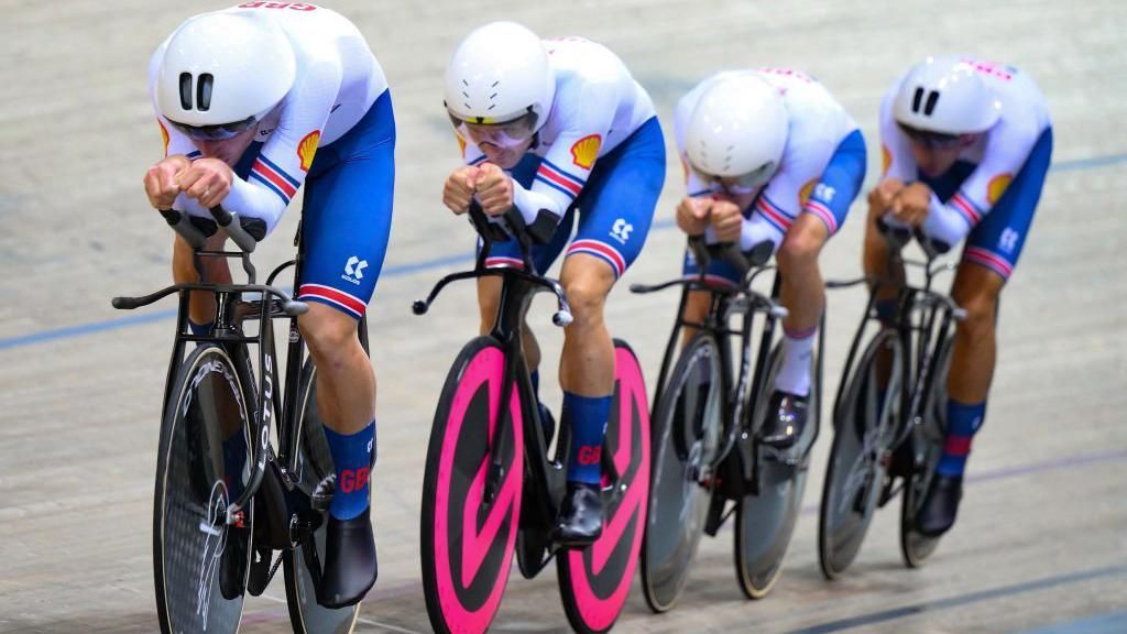 Great Britain men's team pursuit team - featuring Dan Bigham on a pink bike - riding during the 2022 World Championships