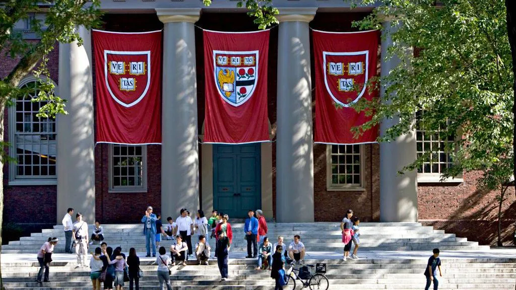 Students gather on the steps of Memorial Church inside Harvard University's campus in Cambridge, Massachusetts