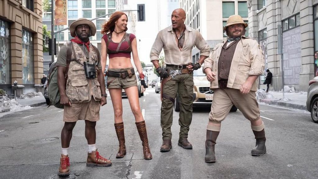 The four cast members of Jumanji in costume posing on a street