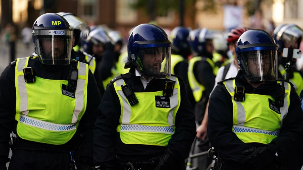 Police officers look on as people attend the 'Enough is Enough' protest in Whitehall, London, following the fatal stabbing of three children at a Taylor Swift-themed holiday club on Monday in Southport