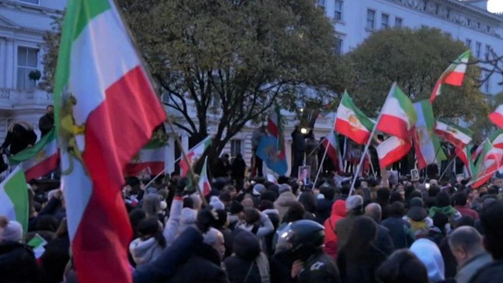 A crowd of protesters outside London's Iranian embassy on Saturday. Some people are waving Iranian flags.
