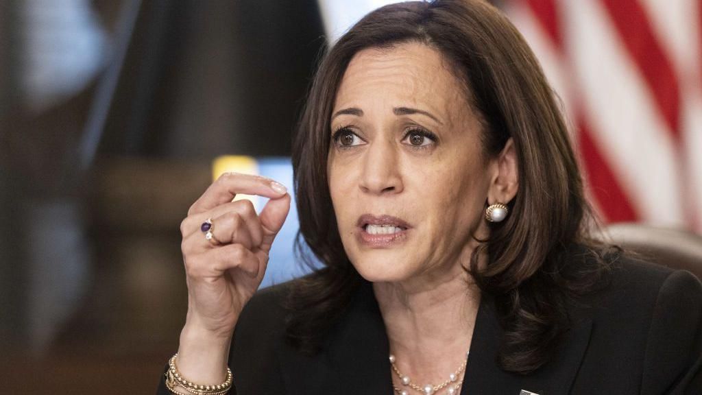 Kamala Harris in dark suit with pearl necklace and earrings