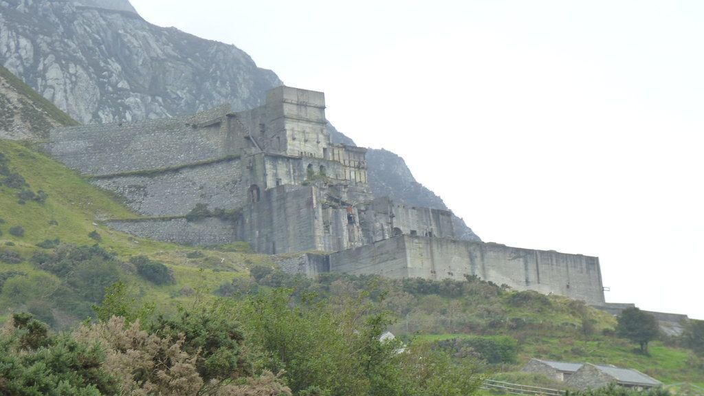 A grey brick quarry building sits aside the mountain at Trefor, North Wales.