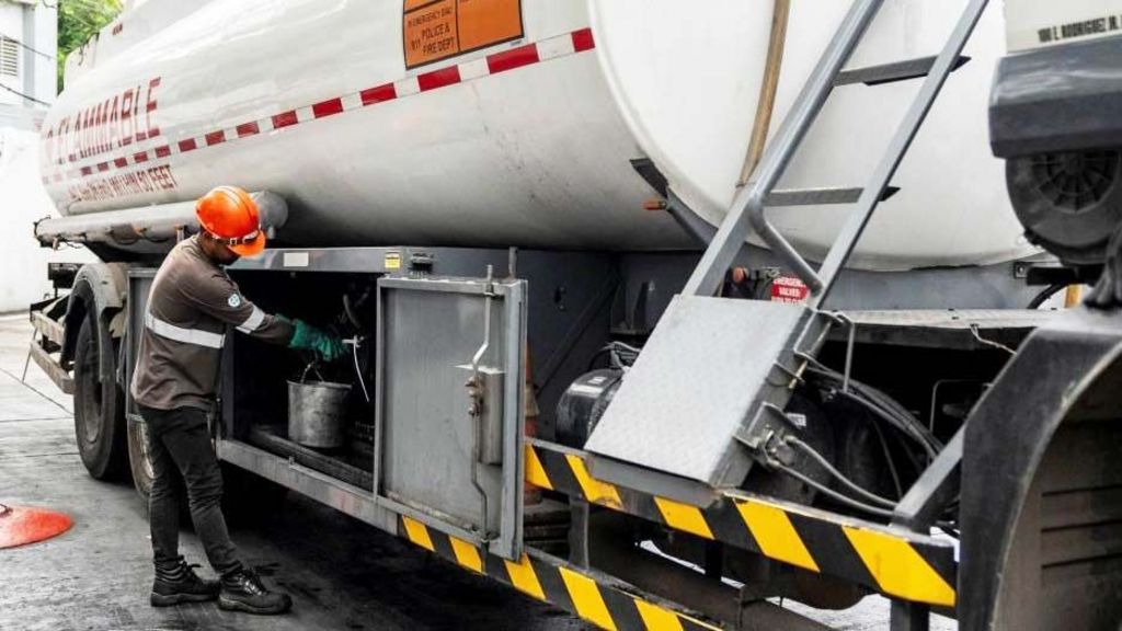 A worker prepares to fill an underground storage tank at a gas station in the Philippines.