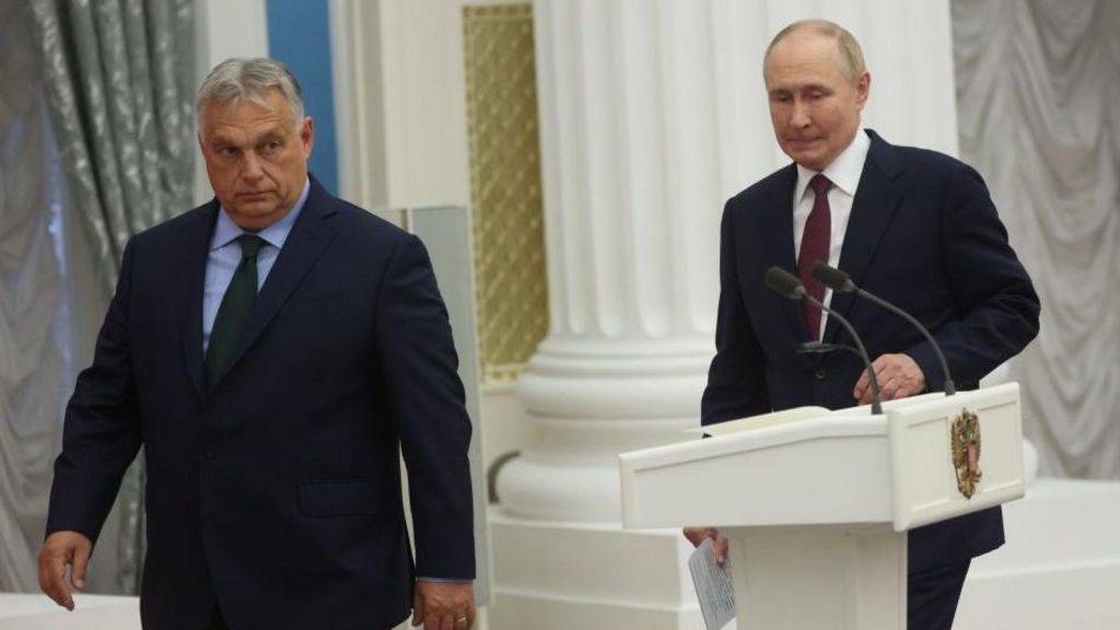 Two men in suits stride past a podium, both looking apprehensive