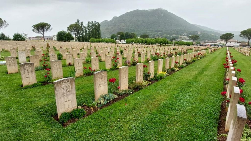Row upon row of graves with the mountain behind 