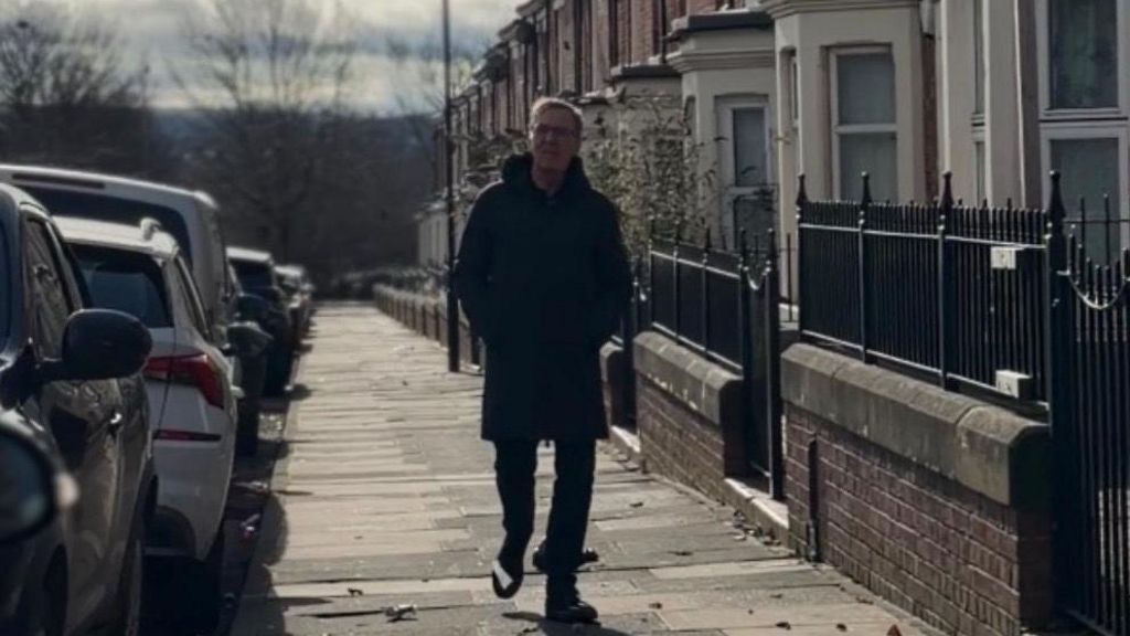 Alan Milburn on a street in Newcastle. He is wearing a dark coat and has his hands in the pockets.