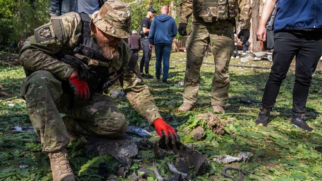  A military expert examines a bomb's fragments collected at the site of a Russian aerial bombing in the Shevchenkivskyi district on May 5, 2024 in Kharkiv, Ukraine