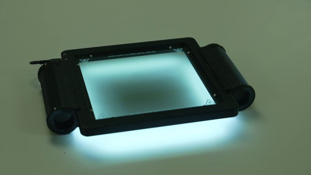 A small black device around the size of an ipad, with a black frame and a viewing pane