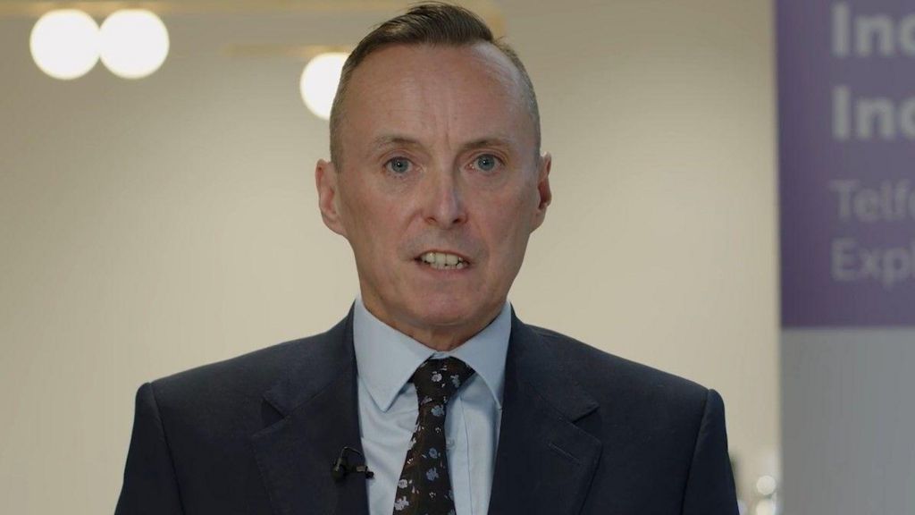 Tom Crowther wearing a dark suit and tie, looking into the camera while delivering a video statement earlier in the inquiry