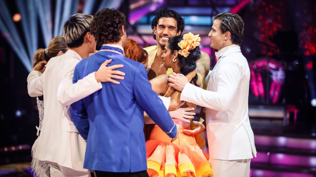 Dancers hug in middle of ballroom