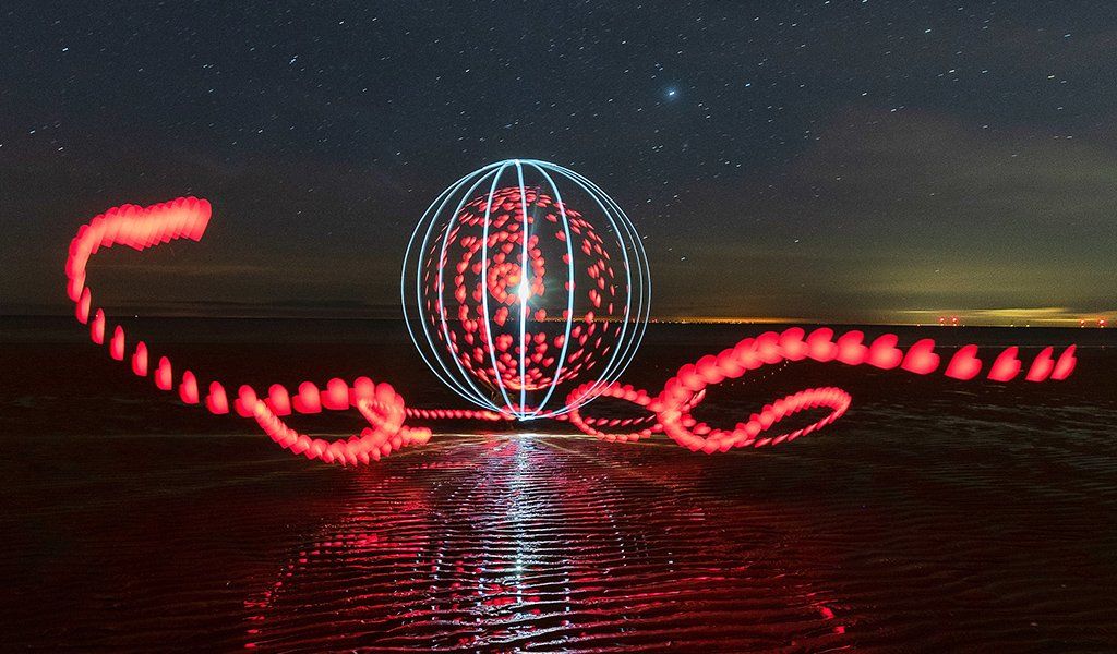 A light painting of red hearts and a white orb filled with hearts on Walton beach in Essex