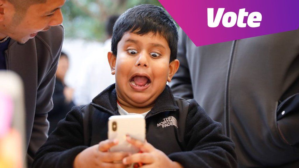 A boy pulls a face at a mobile phone