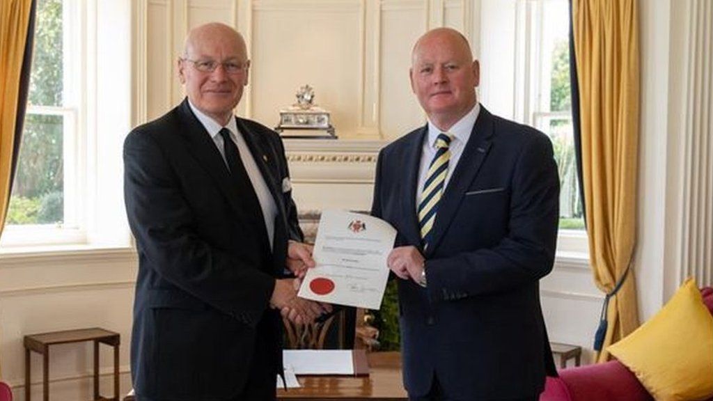 Mr Callister receiving his warrant of appointment from the Lieutenant Governor at Government House