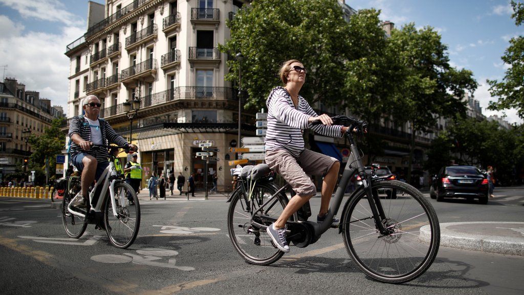 Woman rides her bike through Paris