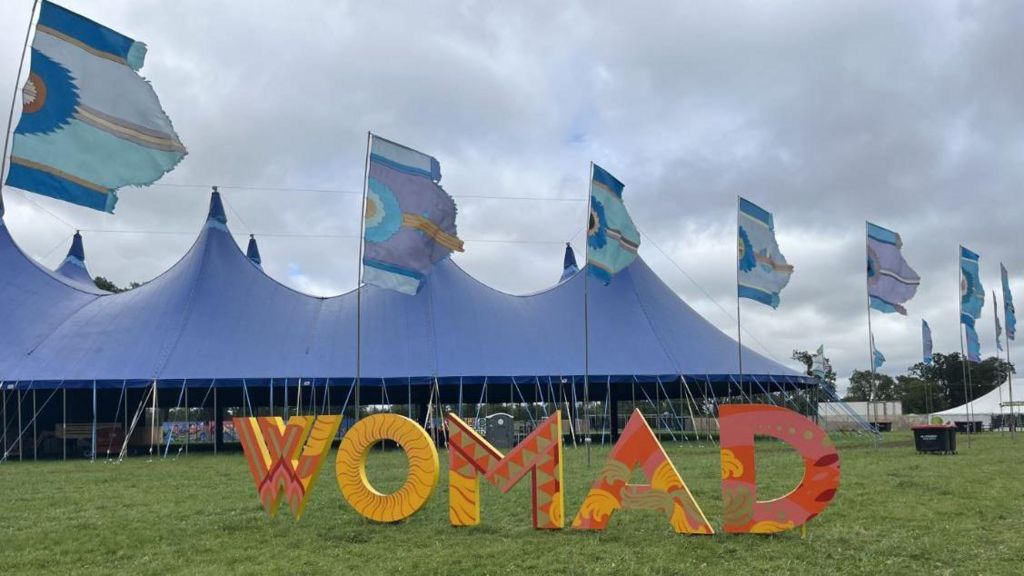 A large orange sign of WOMAD