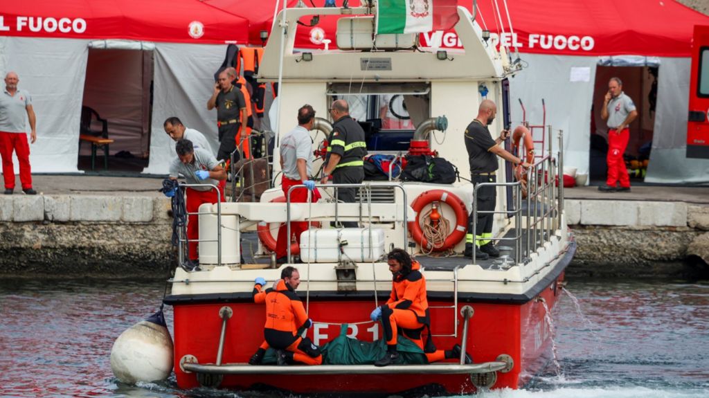 Rescue personnel transport a body after a luxury yacht, which was carrying British entrepreneur Mike Lynch, sank off the coast of Porticello