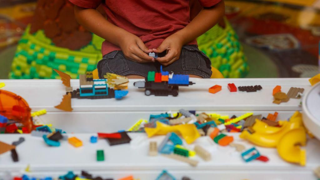 hands constructing a model with Lego bricks