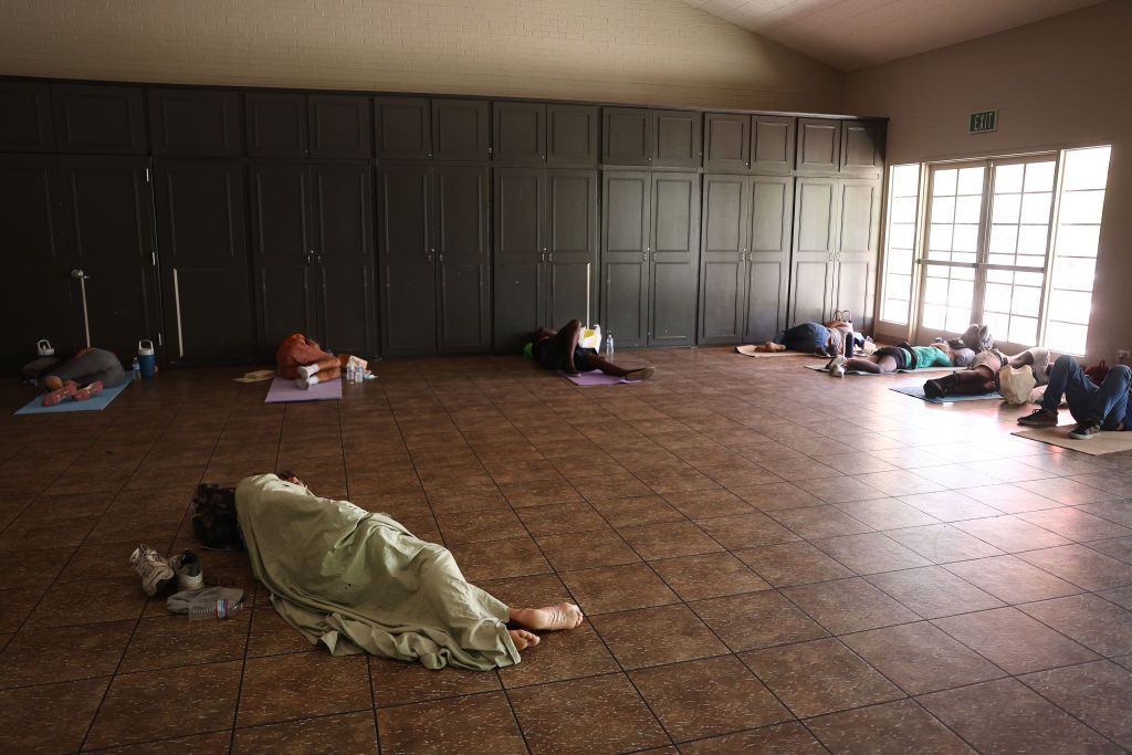 People lay on mats on brown tiled floor