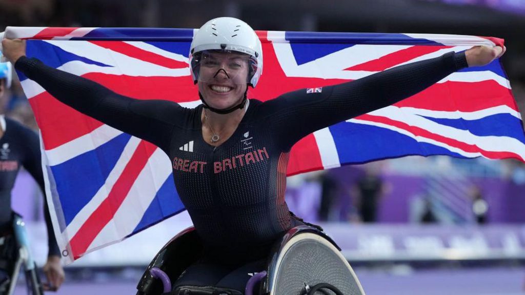 Hannah Cockroft with a Union Jack flag after winning the 800m title