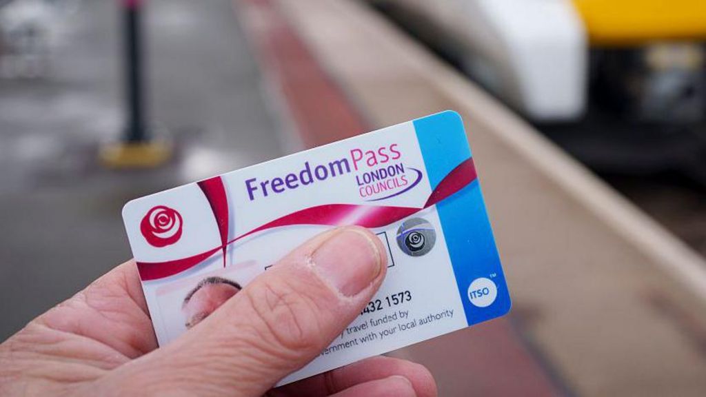 A detail close-up of a hand holding a Freedom Pass issued by Lambeth Council at a south London railway station, on 19th November 2025, in London