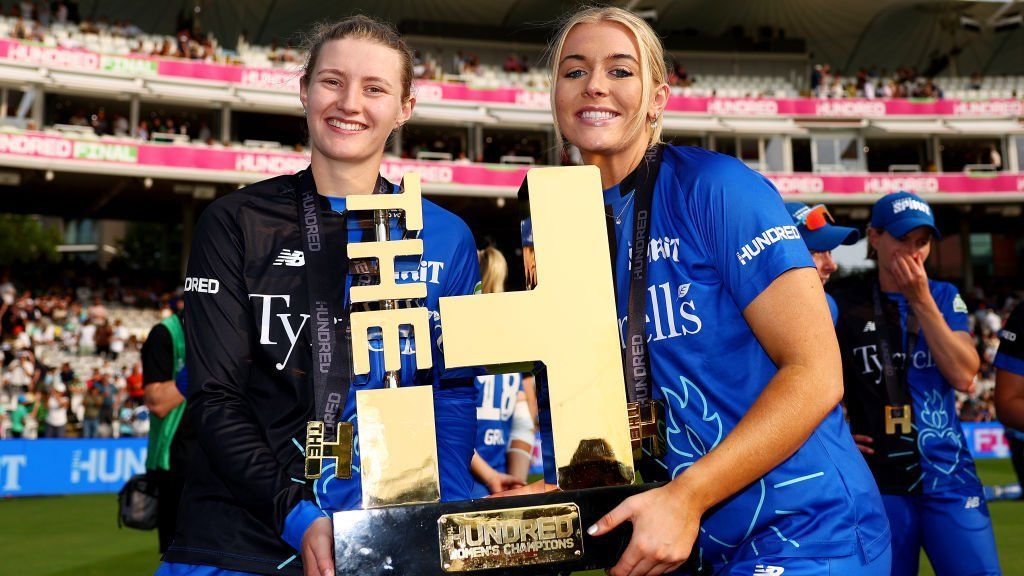 London Spirit players Charlie Dean (left) and Sarah Glenn (right) hold The Hundred trophy