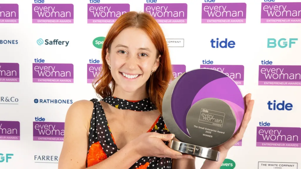 Rose Skuse smiles, holding her entrepreneurship award
