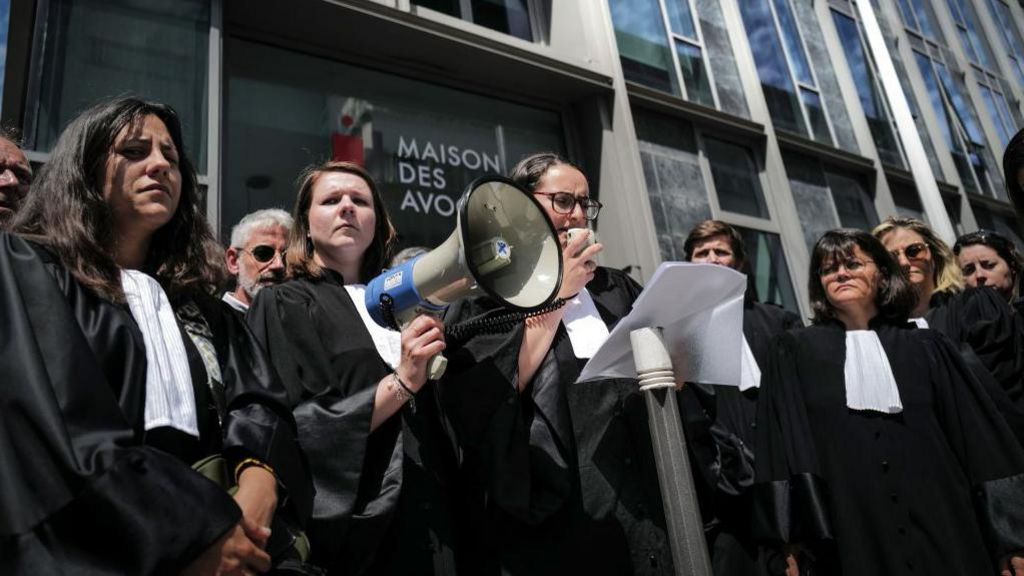 Vice-President of the Lyon Court Bar Sarah Kebir (C) delivers a speech with a megaphone