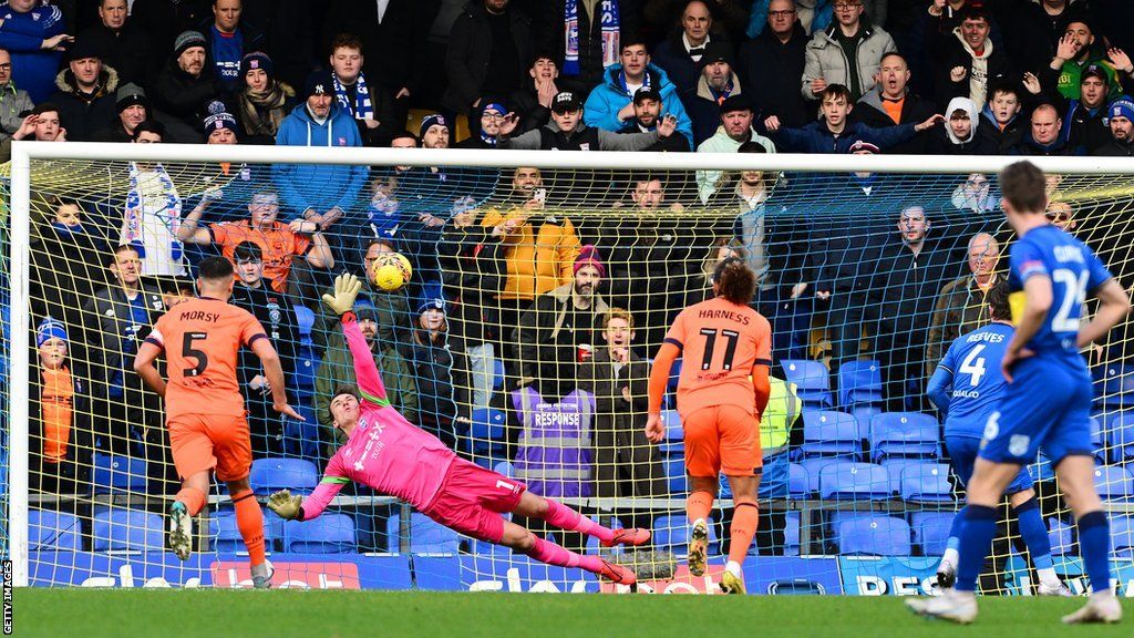 Jake Reeves scores from the penalty spot for AFC Wimbledon against Ipswich Town in the FA Cup