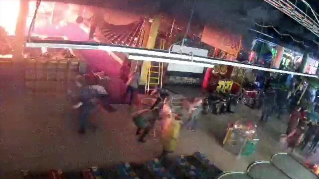 A CCTV grab shows fire pouring from part of the Kemerovo mall as visitors flee in panic