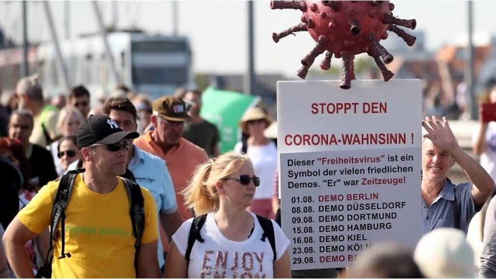 People carrying placards as they take part in an anti-coronavirus restrictions march