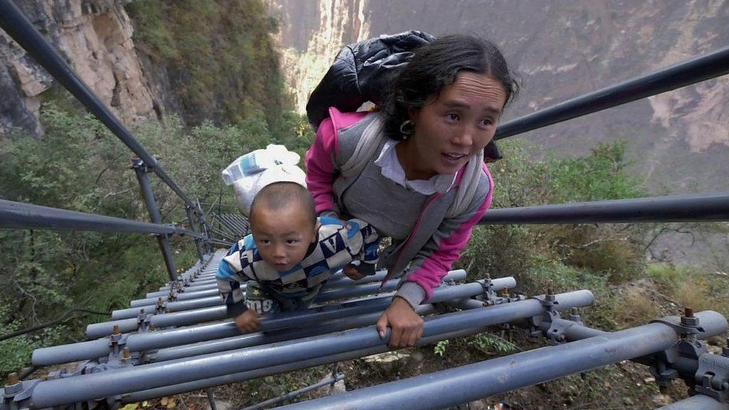 Two people use a new steel ladder in China