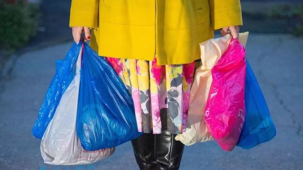 Woman carrying bright plastic bags