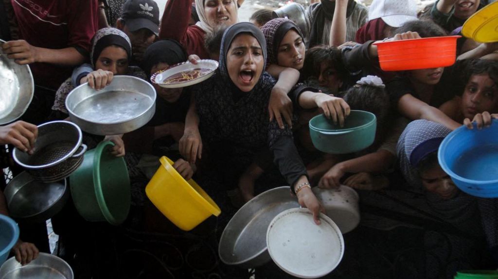 Gaza residents cry out for food at a charity kitchen