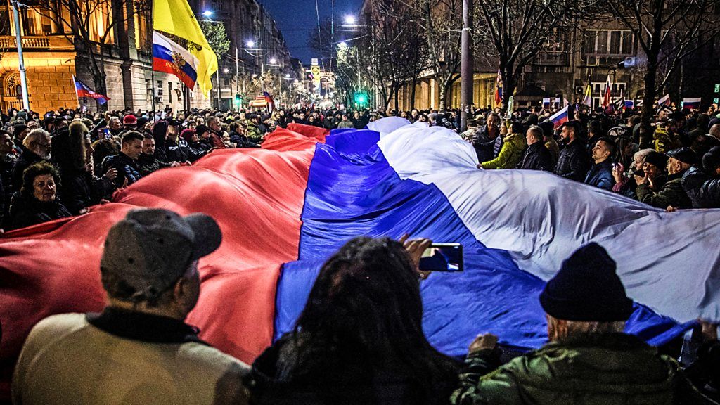 Pro-Russia protesters hold a Russian flag in central Belgrade