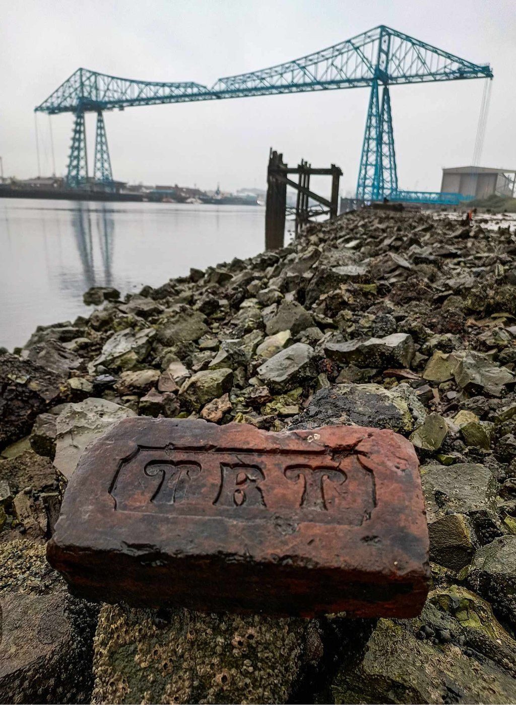 Brick on the foreshore of the River Tees with the transporter bridge in the background